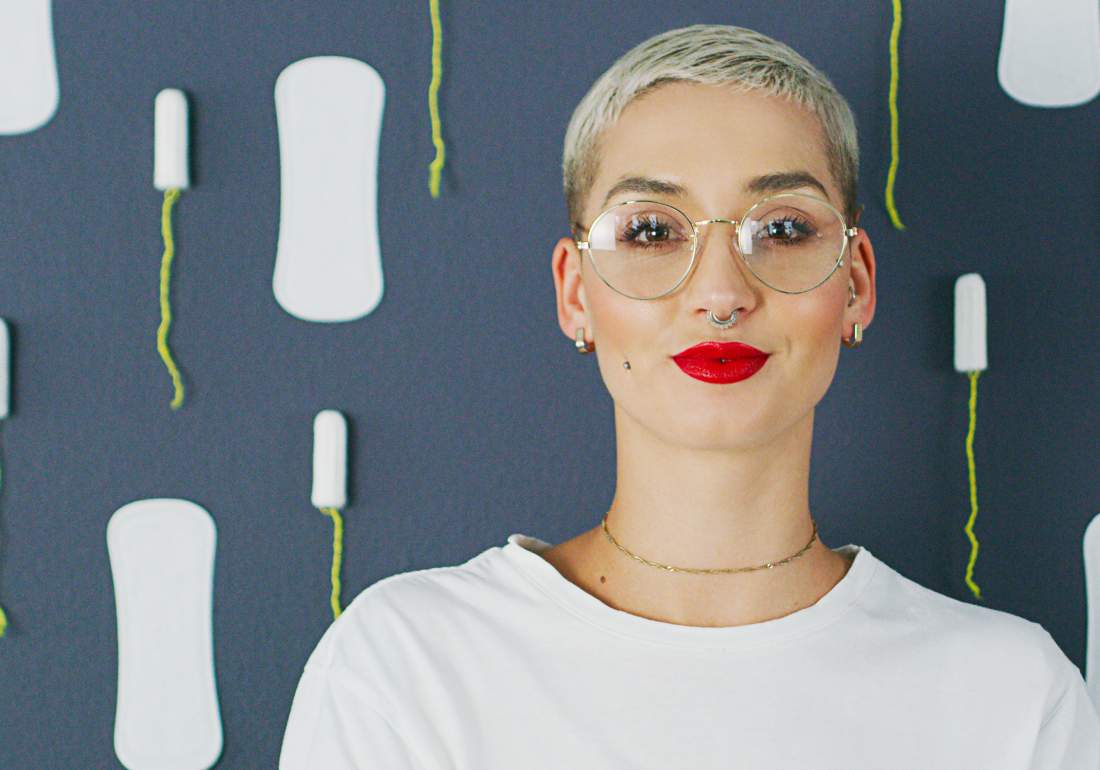 Woman stood with tampons and sanitary pads for endo symptoms