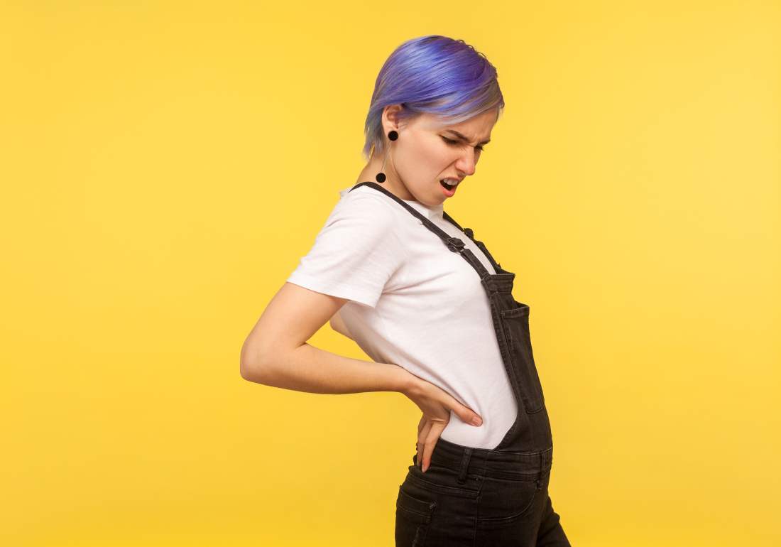 Woman holding bottom of back due to endo symptoms