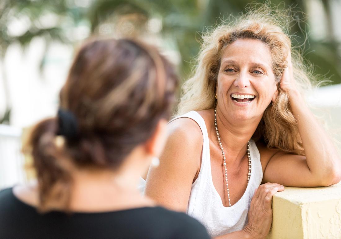 Woman smiling talking with friend about endometriosis