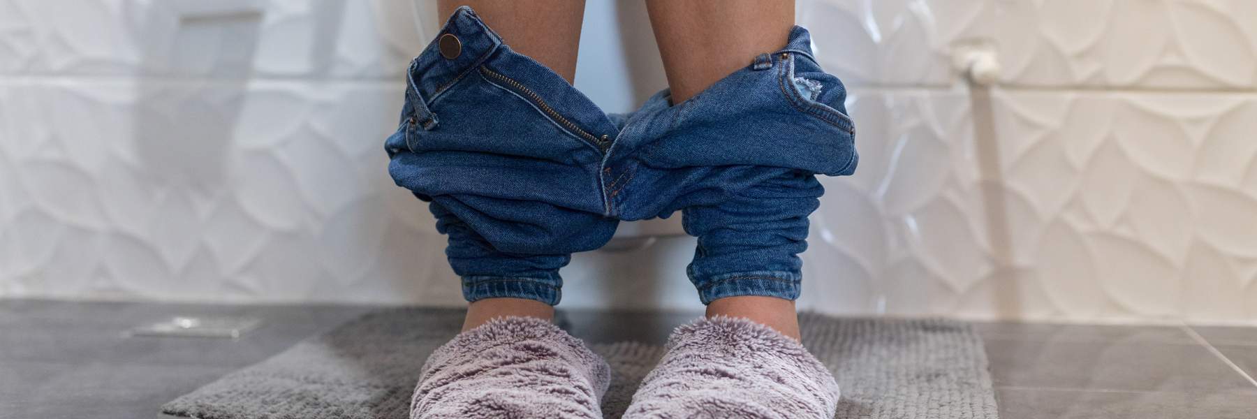 Person sitting on toilet with constipation