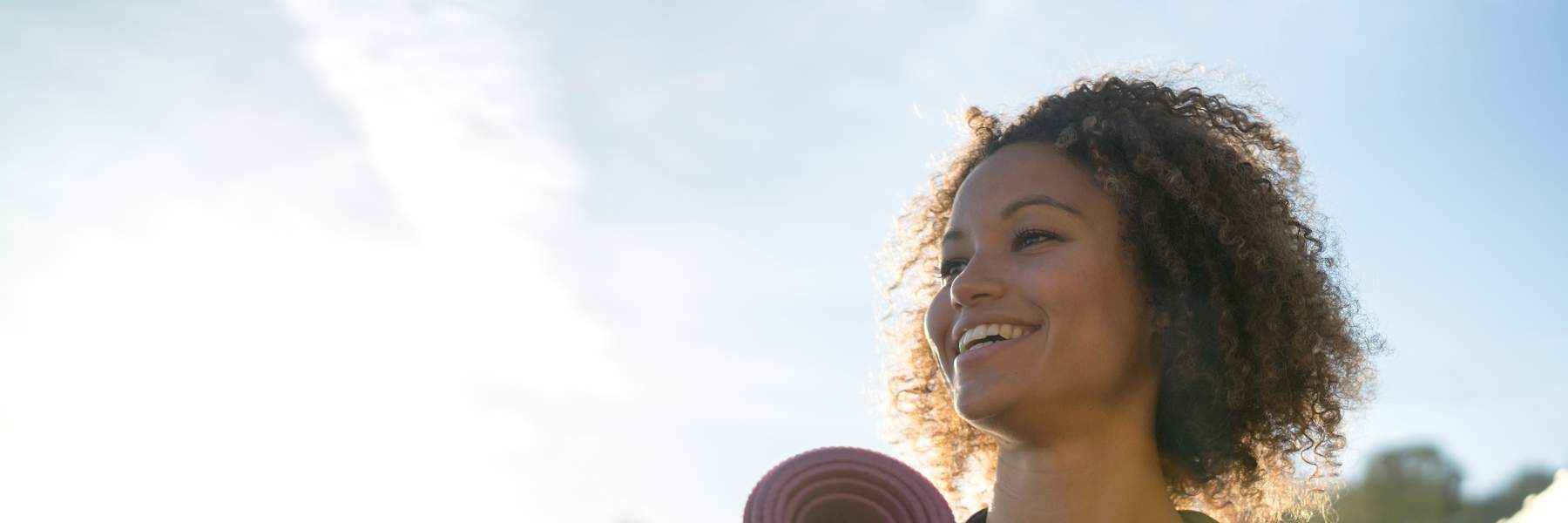 Woman holding yoga mat in exercise gear