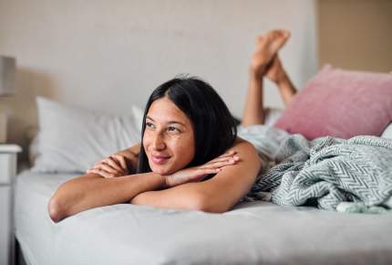 Woman lying in bed and smiling happily