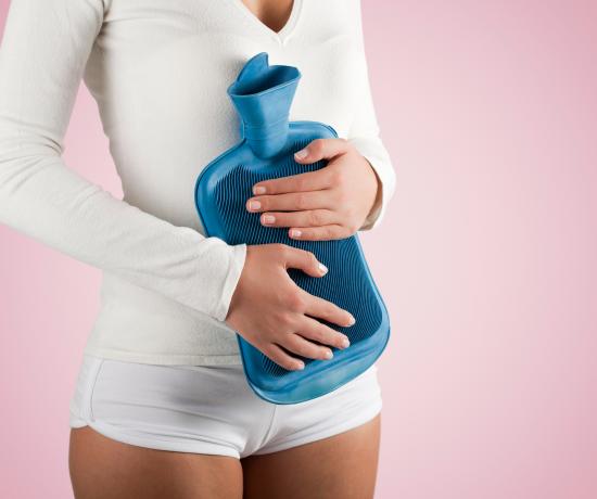 Woman holding water bottle to stomach