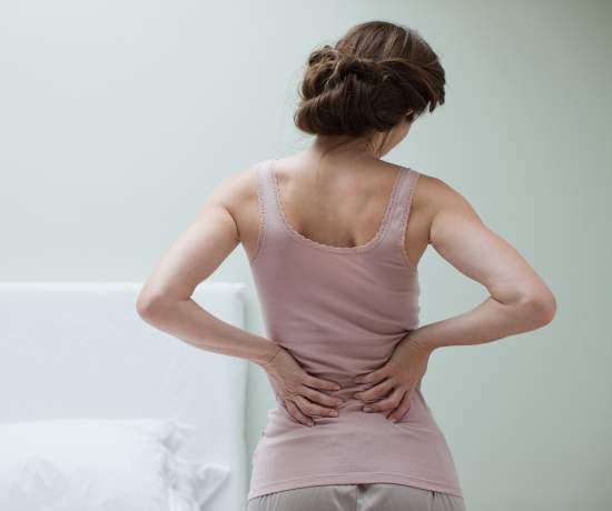 Woman holding bottom of back due to endo symptoms