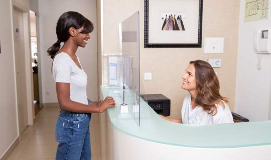 Woman speaking to receptionist